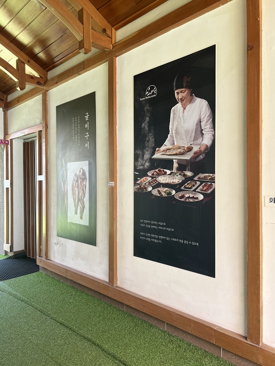 식당 복도의 인테리어. 목재 기둥과 따뜻한 조명으로 한식 당신의 정취를 살렸고, 벽에 붙은 포스터는 정갈한 밥상에 대한 철학을 나타낸다.