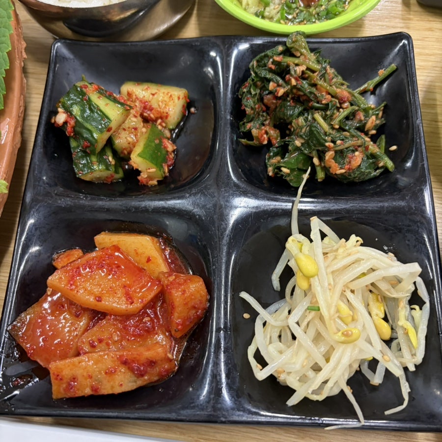오이무침, 나물무침, 깍두기, 콩나물무침으로 구성된 밑반찬.