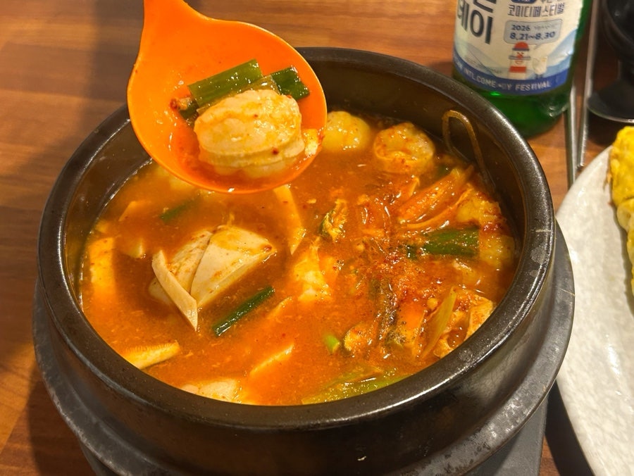 숟가락으로 떠먹는 곱창순두부찌개 클로즈업.