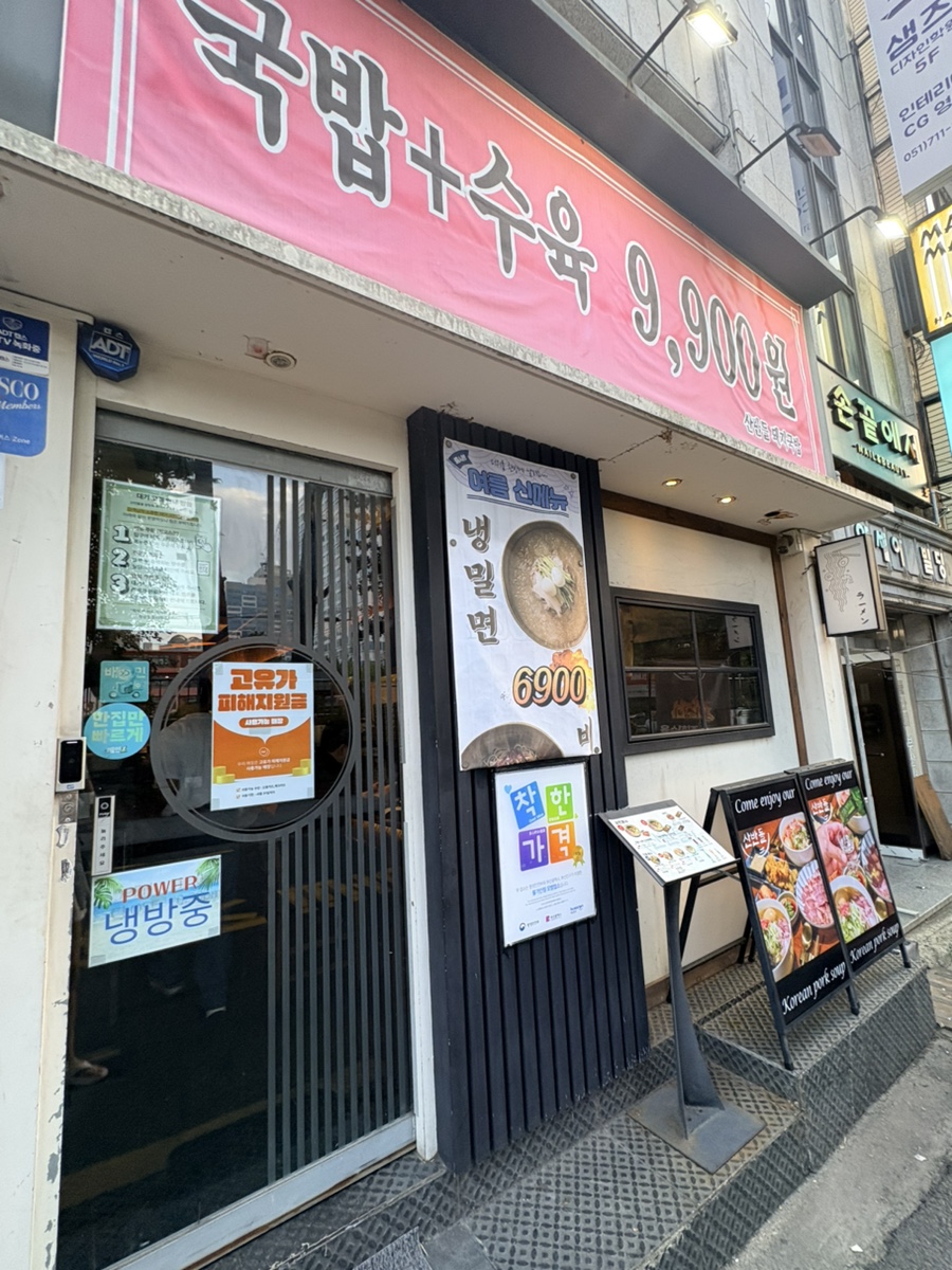 전포카페거리 골목 안 산반들 외관. '국밥+수육 9,900원' 현수막과 착한가격업소 인증 스티커가 붙어 있습니다.