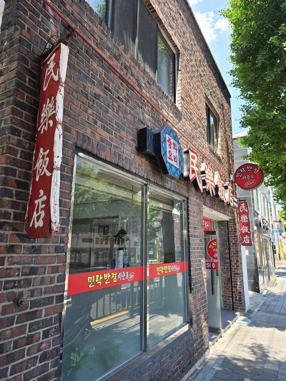 붉은 벽돌 외벽에 남은 '民樂飯店' 세로 간판과 '민락반점 시즌Ⅱ' 배너. 44년째 이 자리를 지켜온 흔적입니다.