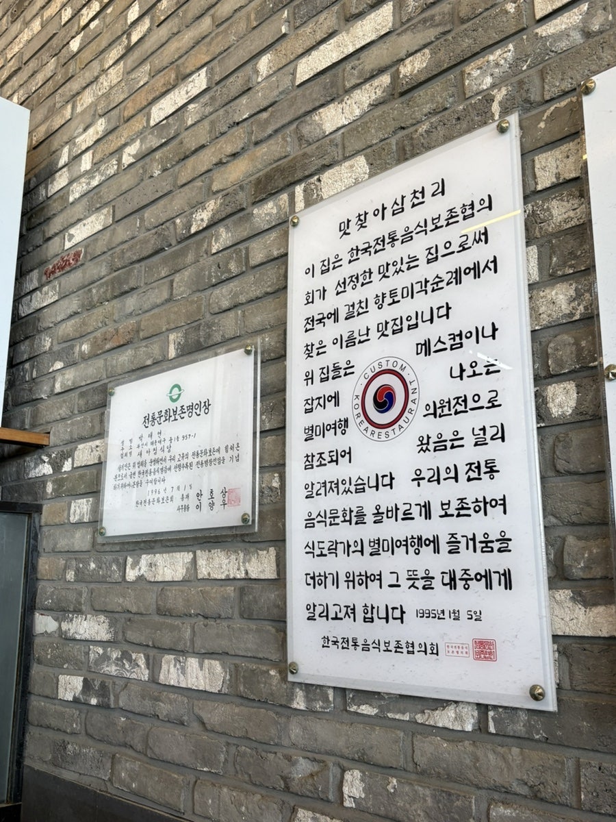 외벽에 나란히 걸린 전통문화보존명인장과 '맛찾아삼천리' 현판
