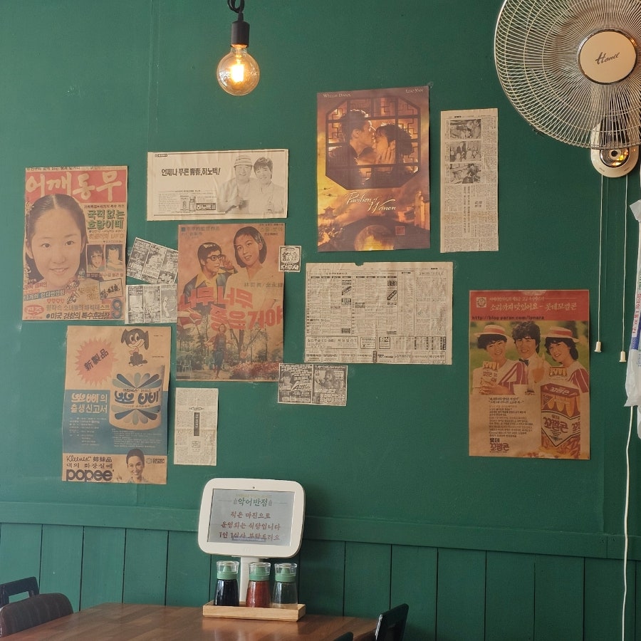 내부 벽면에 붙어있는 수십 년의 흔적. 옛날 포스터와 광고, 그리고 선풍기와 백열전구가 함께합니다.
