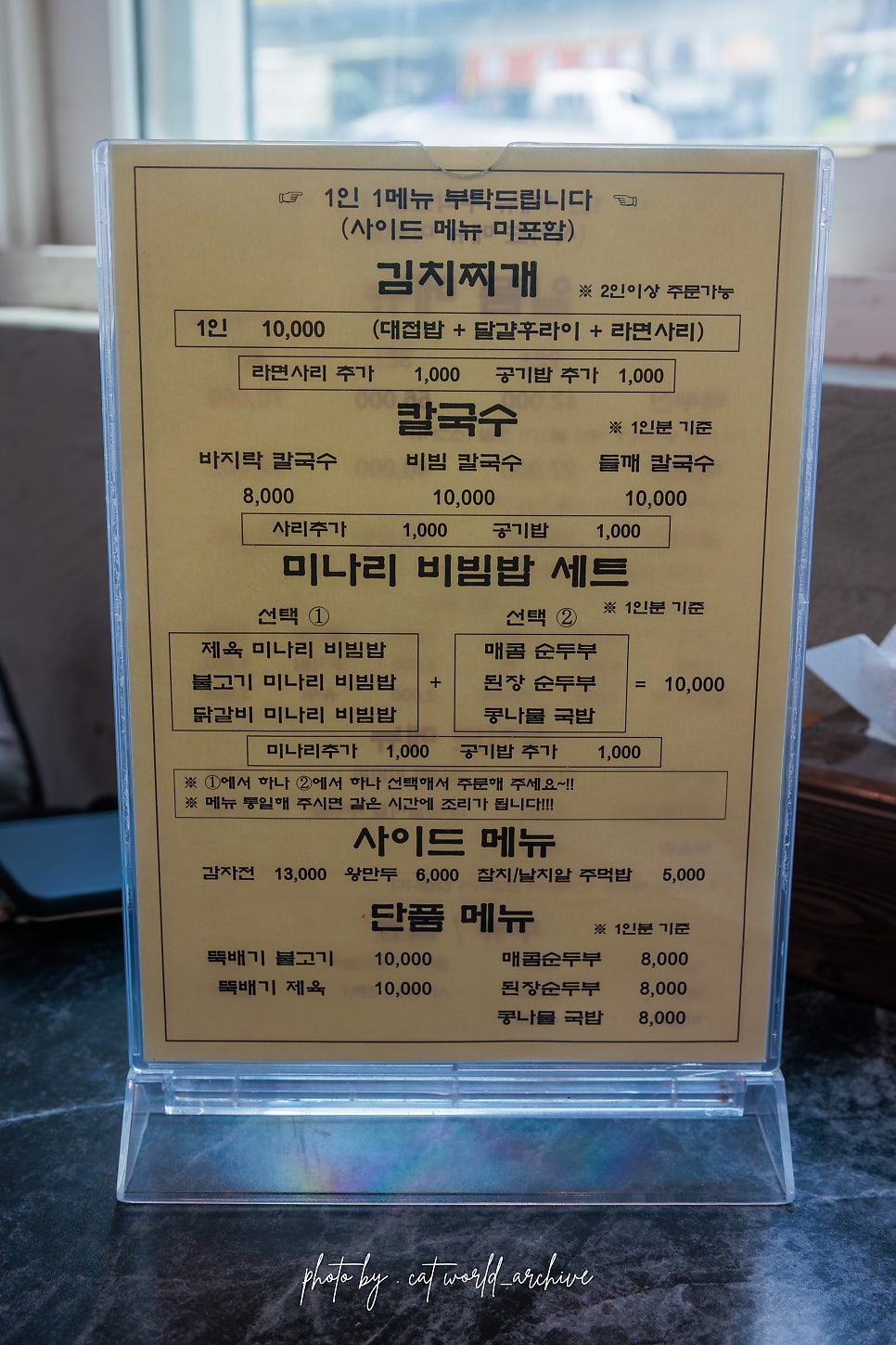 메뉴판. 미나리 비빔밥 세트와 김치찌개, 칼국수의 구성과 가격이 적혀 있습니다.