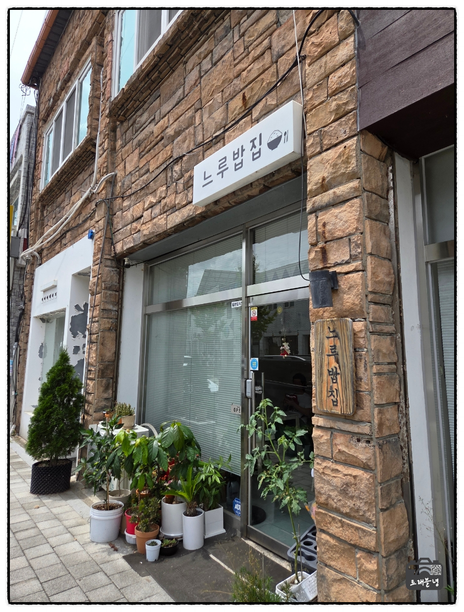느루밥집 입구. 돌담 건물에 작은 간판이 걸려 있고 화분들이 가지런히 놓여 있어, 처음 보면 식당인 줄 모르고 지나치기 쉽습니다.