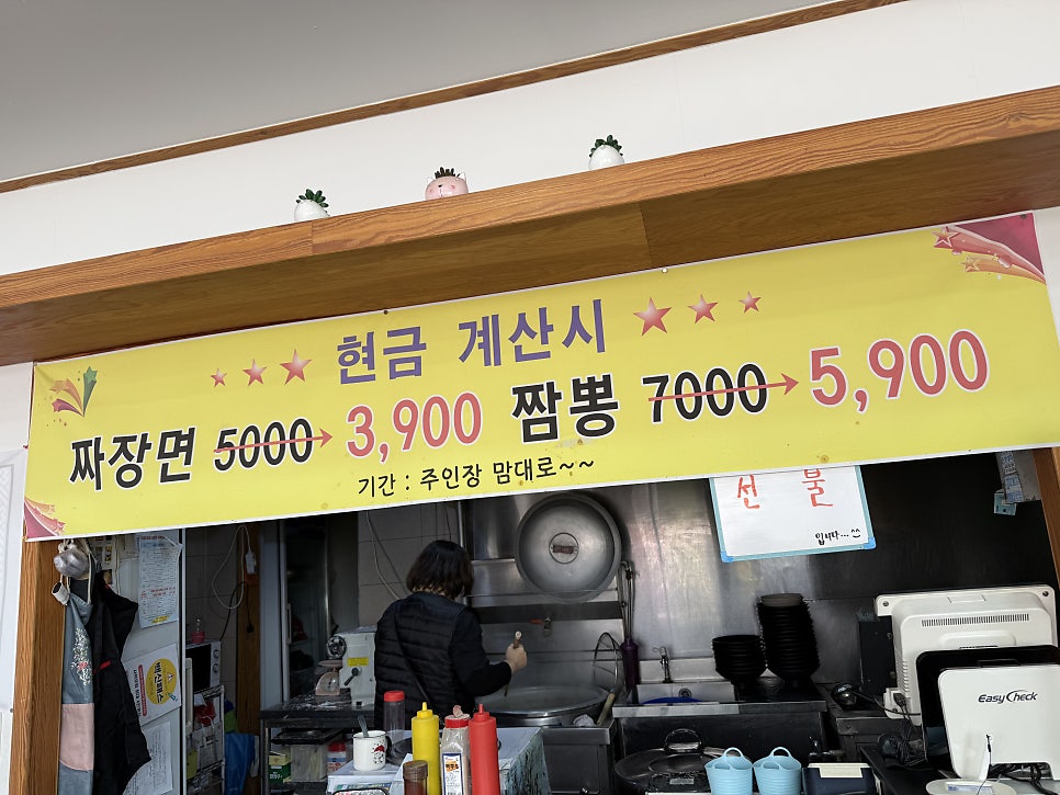오픈 주방과 주문 카운터. 현금 계산 시 할인 안내가 보입니다.