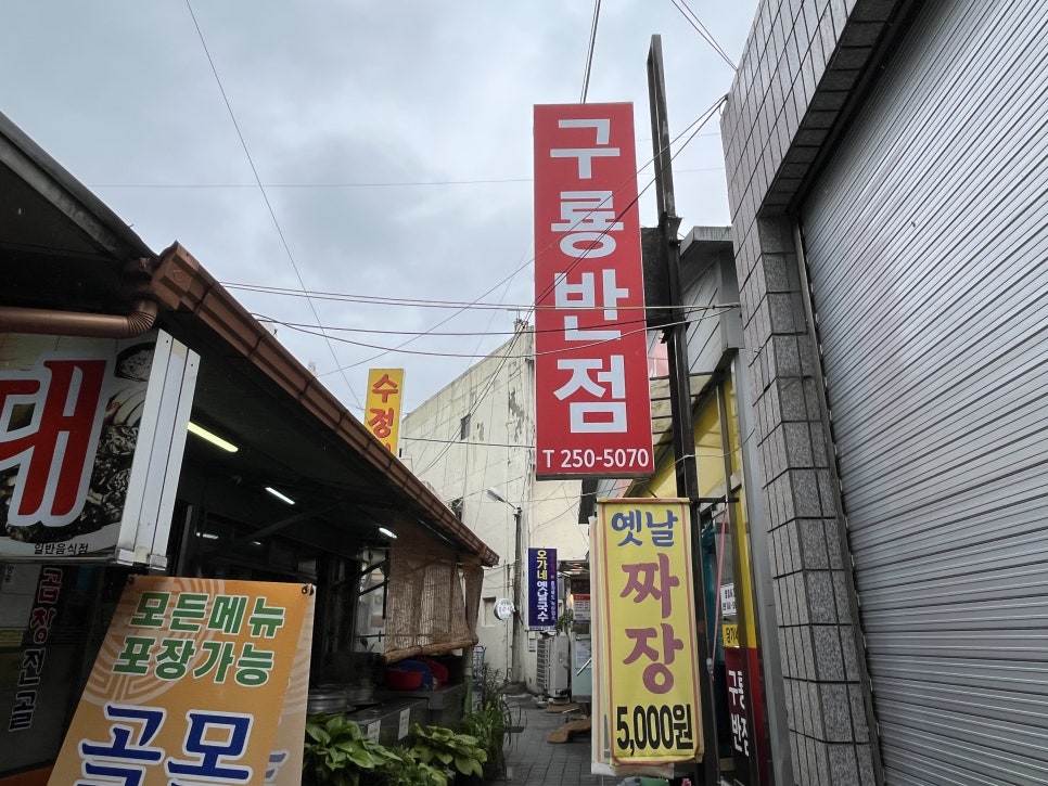 구룡반점 간판. 빨간색 벽면에 흰 글씨로 크게 '구룡반점'이라고 표시되어 있습니다.