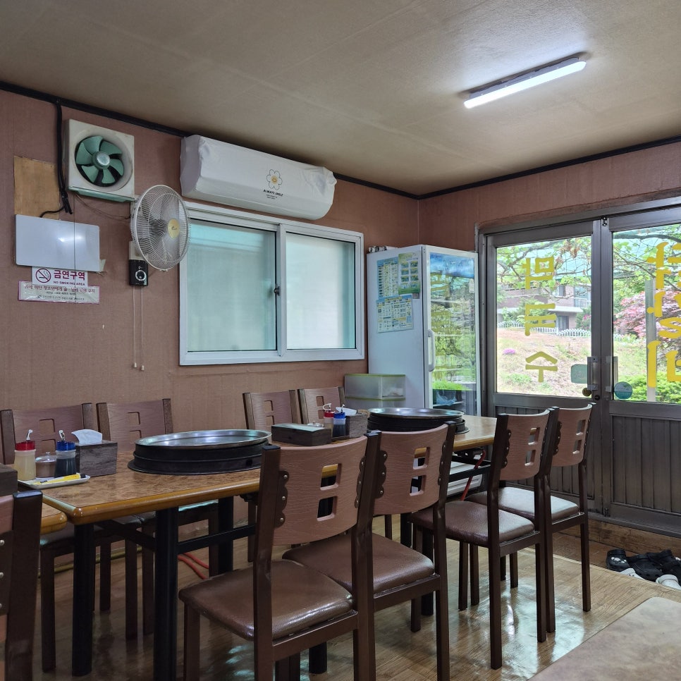 테이블마다 불판이 놓인 실내 좌석. 창밖으로 정원이 보입니다.