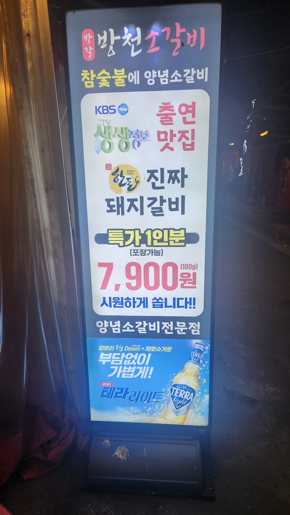 매장 앞 입간판. 참숯불 양념소갈비 전문점이며 돼지갈비 1인분(180g) 특가 7,900원, 포장 가능 안내가 적혀 있다. KBS 2TV 생생정보 출연 이력도 함께 표기돼 있다.