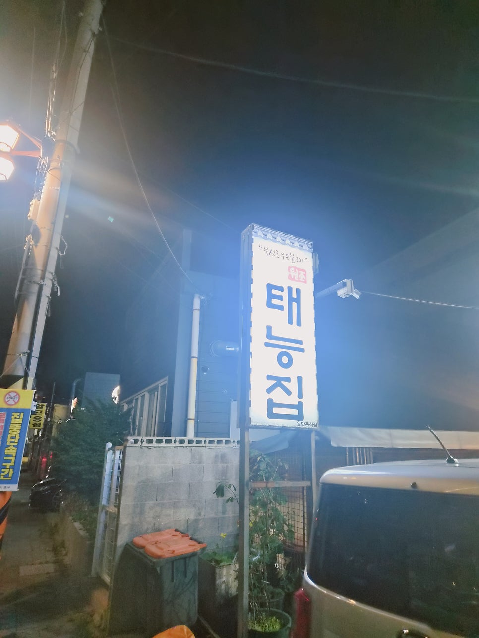 밤에 불을 밝힌 태능집 간판. '북성로우동불고기'와 '원조' 문구가 함께 적혀 있습니다.