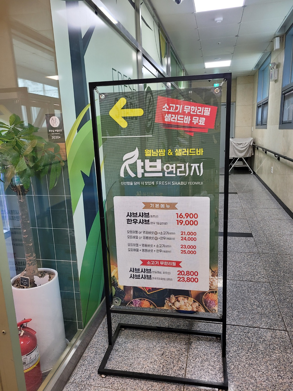 매장 입구에 놓인 메뉴판. 기본 샤브샤브 16,900원부터 소고기 무한리필 메뉴까지 가격이 안내되어 있다.