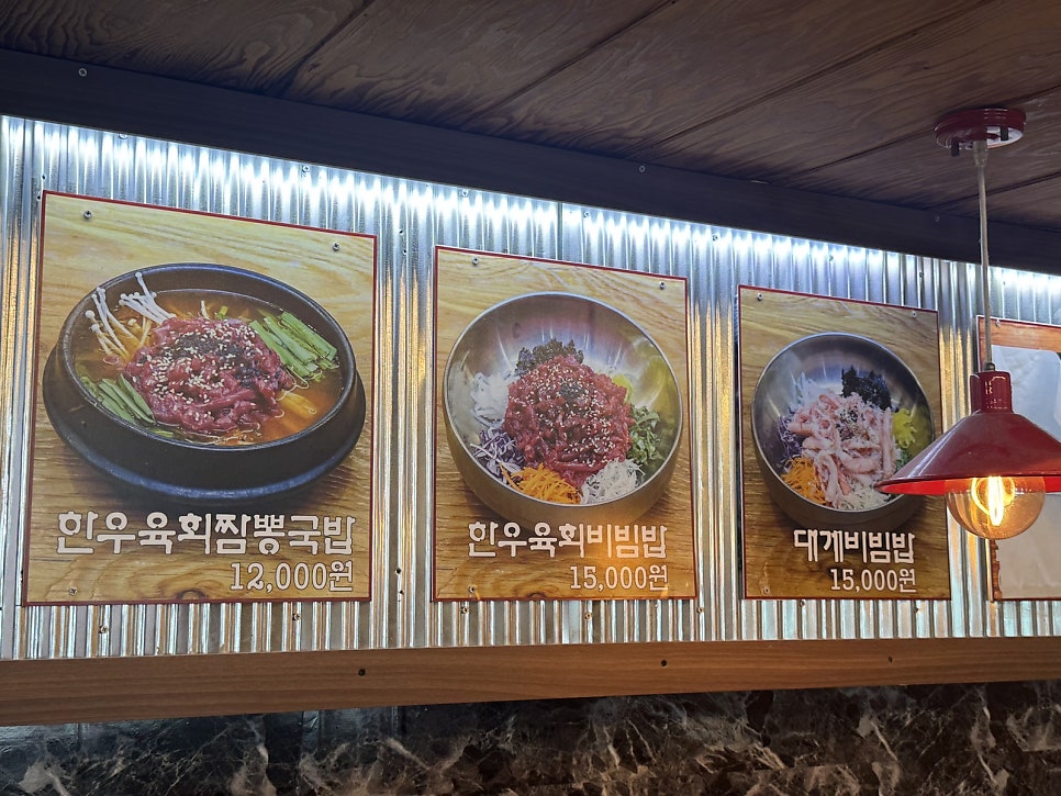 매장 안에 걸린 메뉴 사진. 한우육회짬뽕국밥·한우육회비빔밥·대게비빔밥이 나란히 걸려 있다.