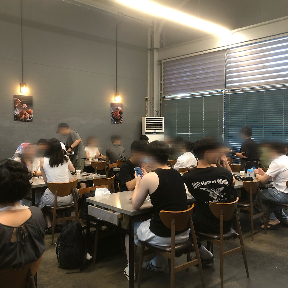 가게 내부 모습. 우드톤 테이블과 벽면에 문어 음식 사진이 장식되어 있습니다.