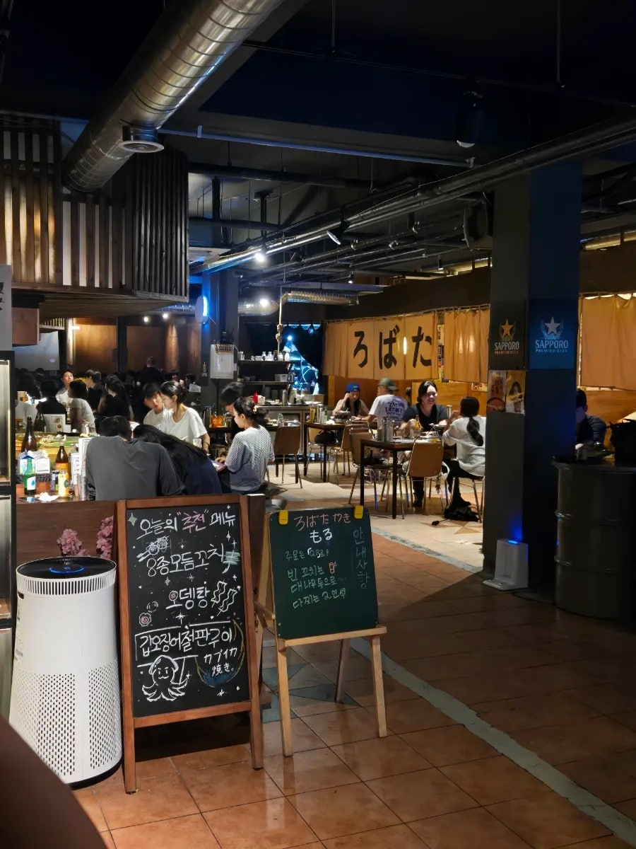 매장 내부의 활기찬 분위기. 이자카야다운 카운터와 테이블