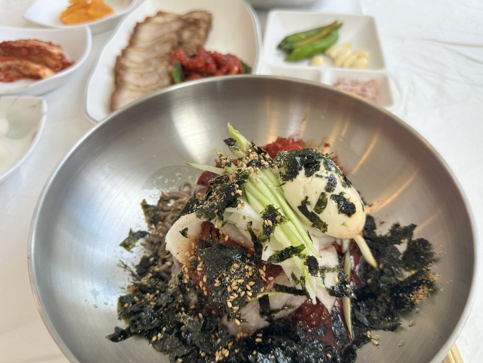 오이·삶은 달걀·김가루 고명을 올린 막국수. 새콤달콤한 양념과 육수의 시원함이 함께 느껴집니다.
