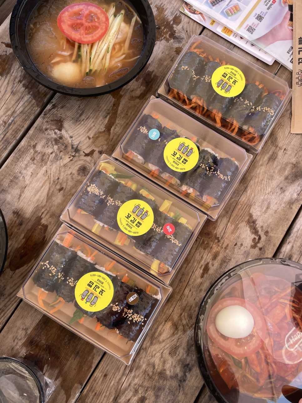 포장해온 꼬마김밥과 오뎅탕을 해변 나무 테이블에 펼쳐놓은 모습. 물놀이 중간에 간단히 요기하기 좋습니다.