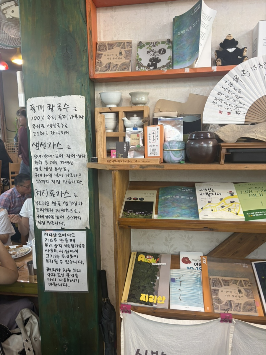 한문 서예·책·도자기로 채운 목재 선반. 감성 있는 한옥 인테리어입니다.