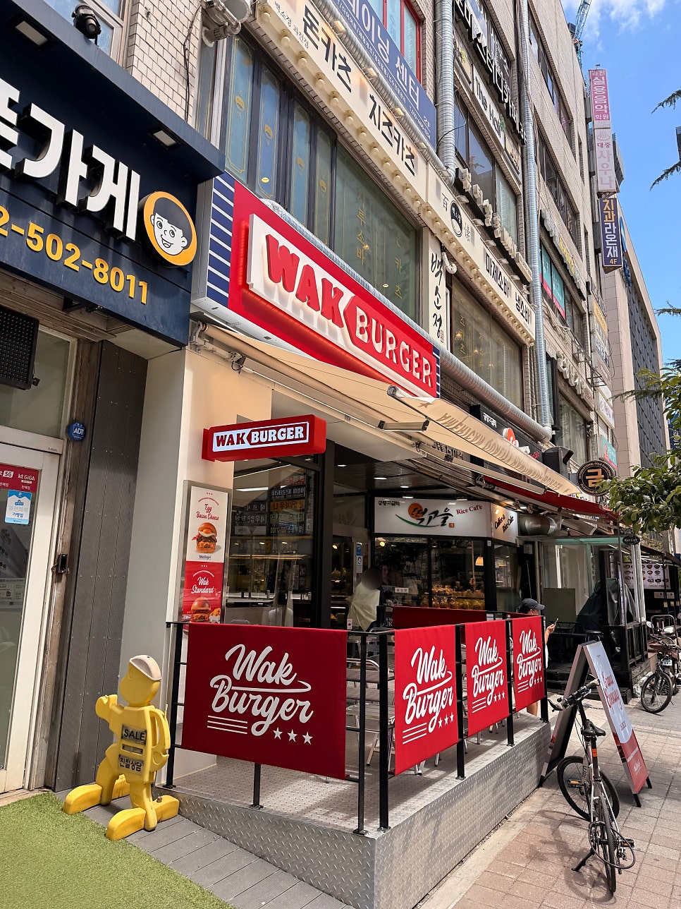매장 입구. 야외 테라스와 브랜드 배너가 나란히 자리해 있습니다.