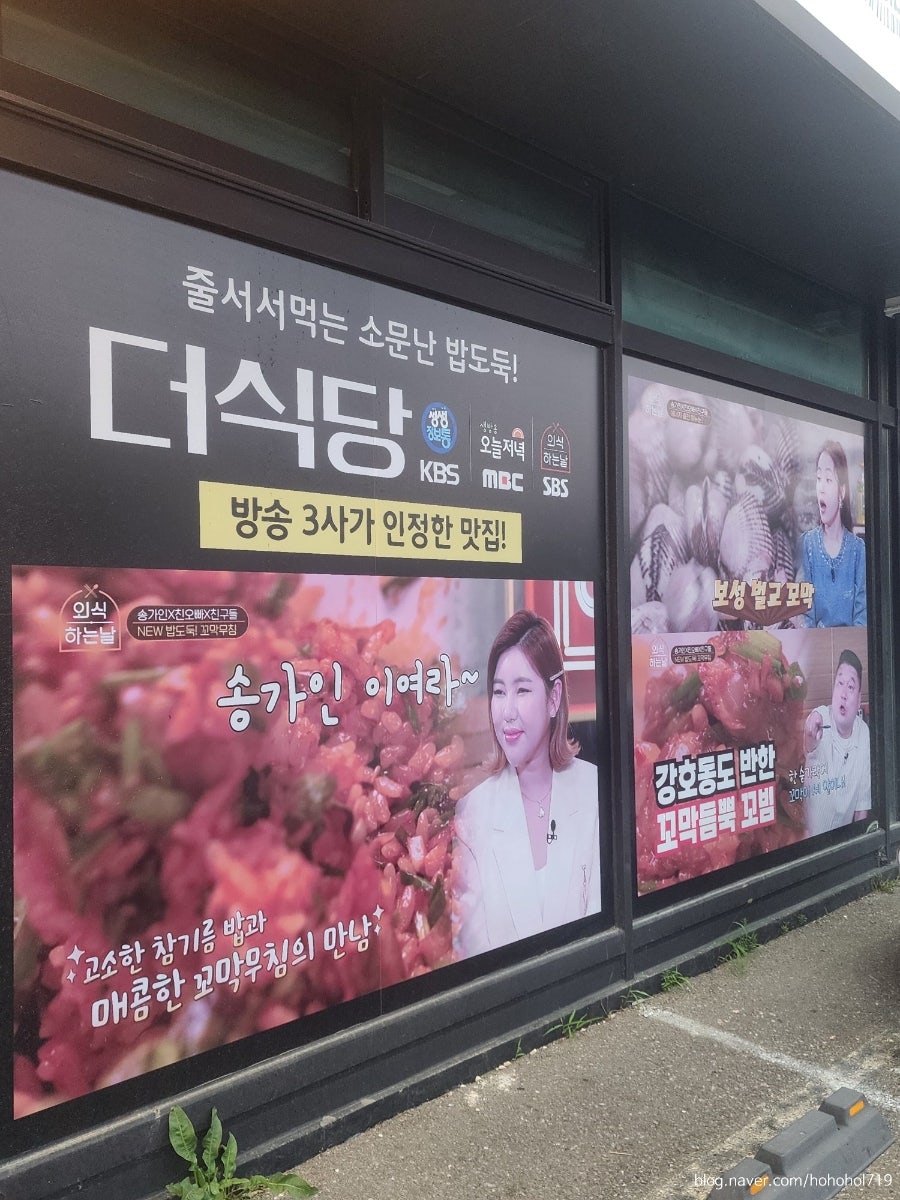 매장 외벽에 붙은 방송 소개 홍보물. 꼬막무침 등 곁들임 메뉴를 알리는 문구도 함께 보입니다.