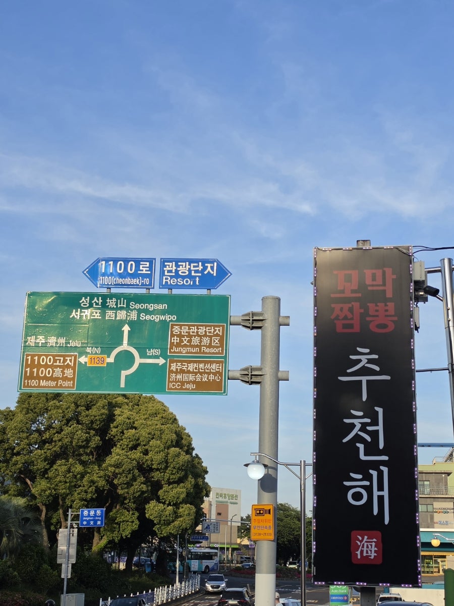 가게 간판과 중문관광단지 위치 표지판.