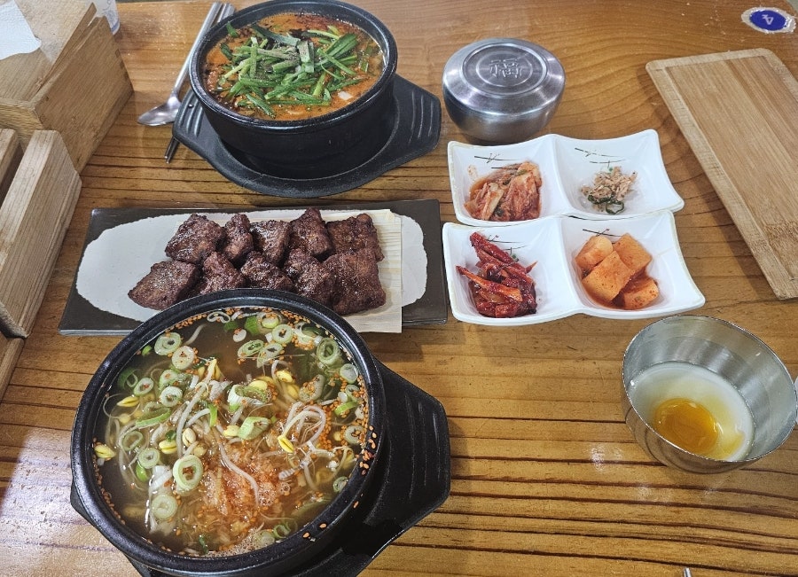 콩나물국밥·얼큰돼지국밥에 떡갈비까지 곁들인 한 상. 수란을 국물에 풀어 비벼 먹으면 더 고소하다.