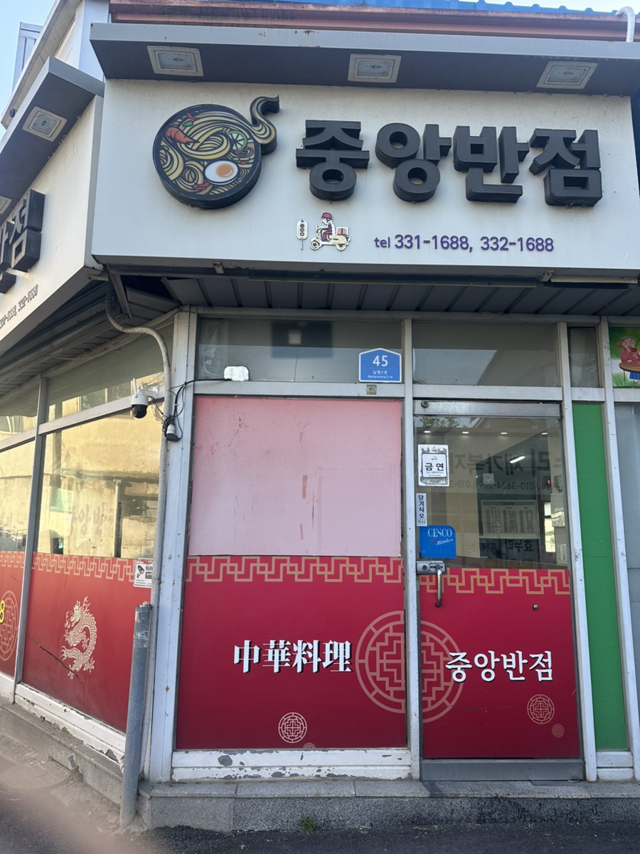 중앙반점 간판. 검은 글씨의 현판과 오래된 느낌의 간판이 특징입니다.