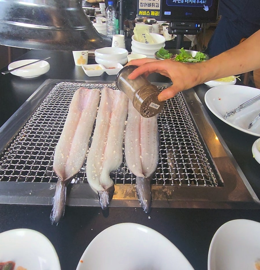 손질된 민물장어를 석쇠에 올리고 밑간을 뿌리는 모습. 초벌 직전 단계입니다.