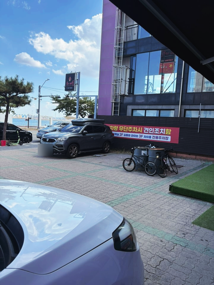 차이홍 전용 주차장. 매장 앞으로 8~10대가량 세울 수 있고, 무단주차 시 견인 조치된다는 안내문이 붙어 있으니 지정된 구역 안에 주차하세요.