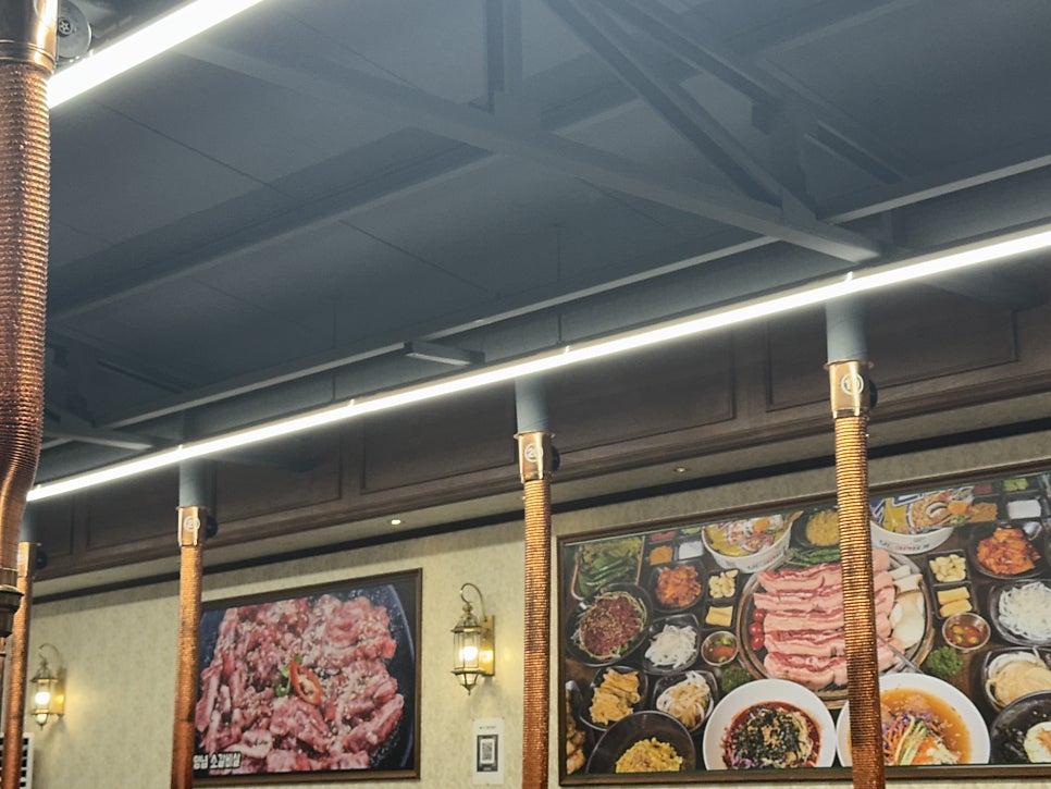 테이블마다 따로 연결된 구리색 닥트(연통). 개별 배기 구조 덕분에 여러 테이블이 동시에 고기를 구워도 냄새 부담이 적습니다.