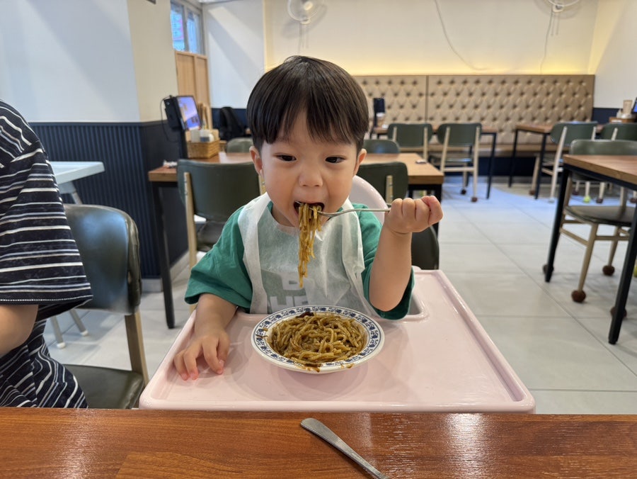 아기의자에 앉아 짜장면을 먹는 아이. 턱받이만 챙기면 아이도 편하게 식사할 수 있는 분위기입니다.