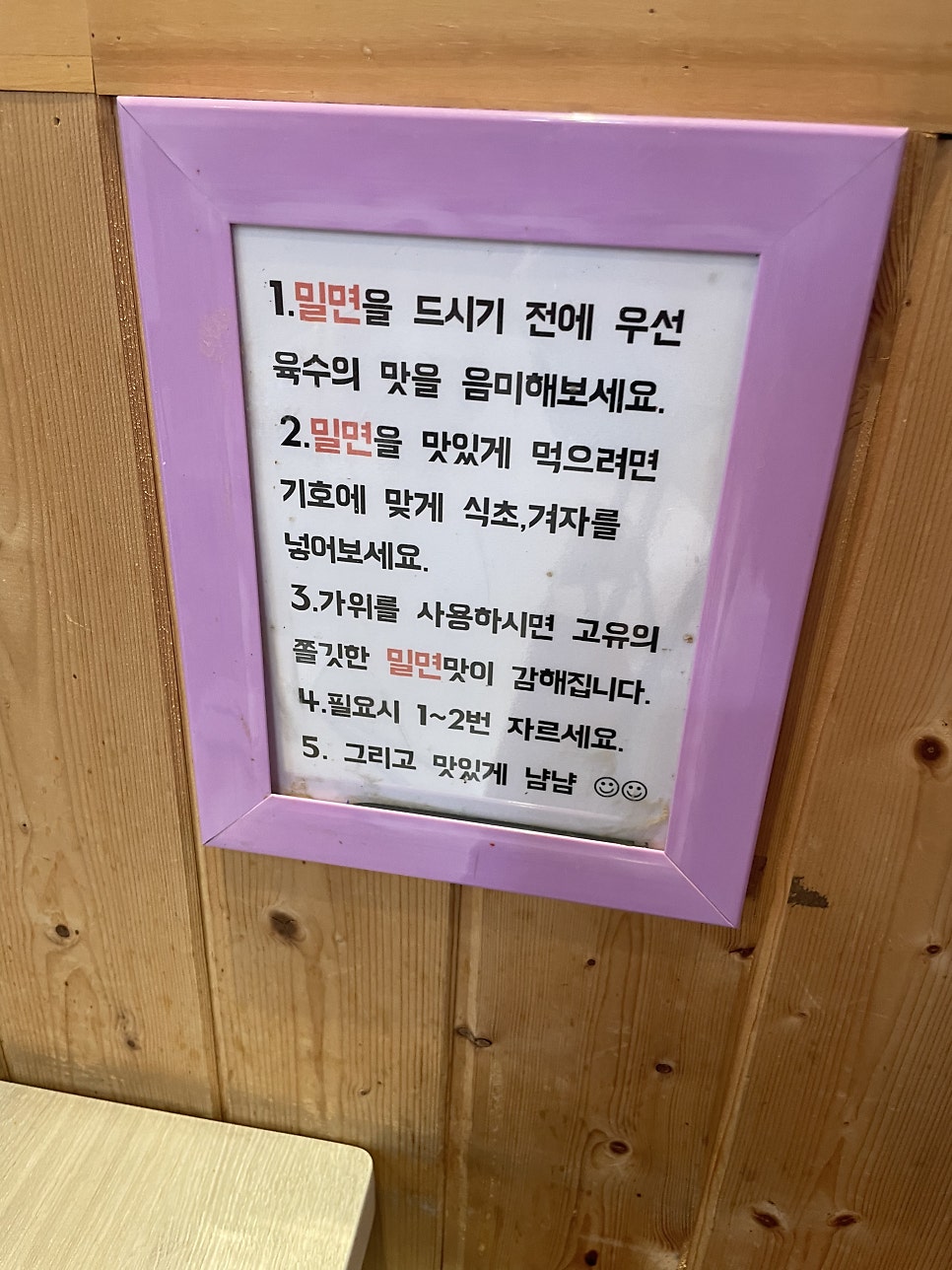 밀면을 더 맛있게 먹는 법을 적어둔 안내판. 육수 맛을 먼저 보고, 식초·겨자는 취향껏, 가위질은 1~2번만 하는 게 요령입니다.