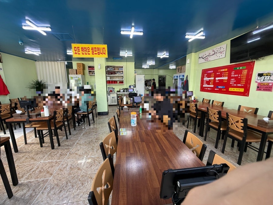 식사 시간대의 매장 내부. 테이블이 많고 손님들로 붐빕니다.