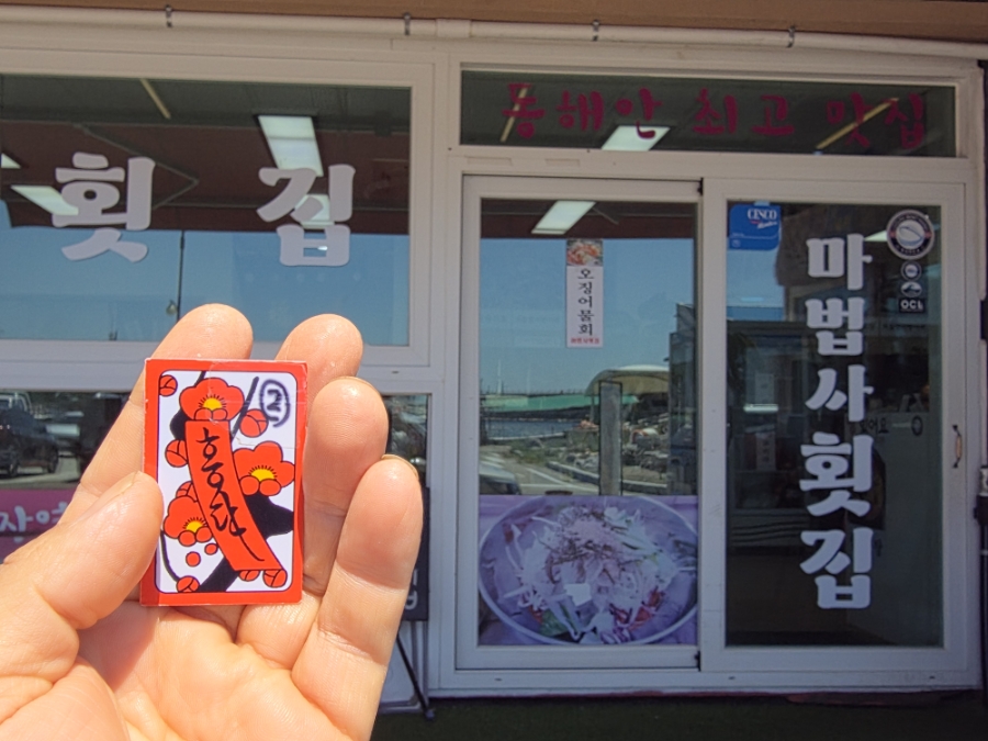 화투로 된 웨이팅 번호와 마법사중화요리 지도, 건물이 보이는 배경.