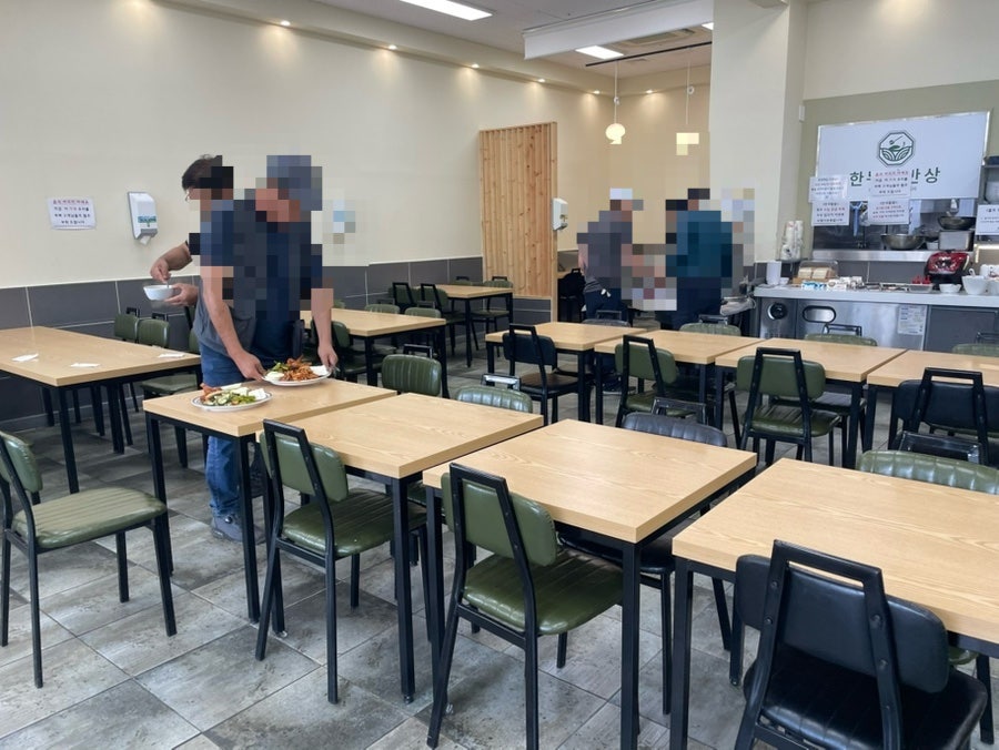 매장 내부 테이블 좌석. 손님들이 담아온 반찬과 밥을 들고 자리로 향한다.