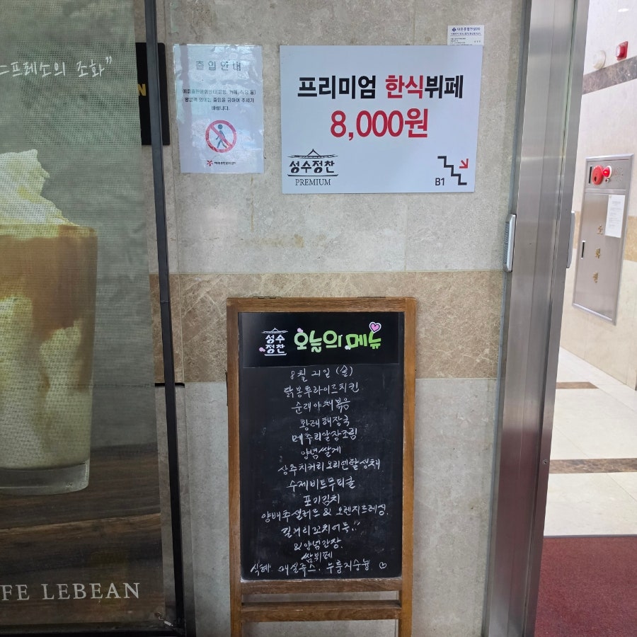 지하 매장 입구. 프리미엄 한식뷔페 8,000원 안내판과 오늘의 메뉴 칠판이 함께 있다
