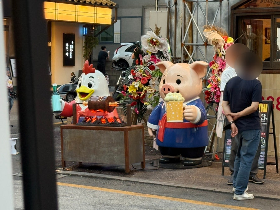 가게 앞의 장식들. 돼지와 닭 캐릭터가 인사합니다.