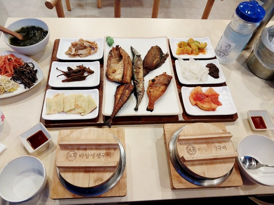 생선구이 정식 상차림. 여러 마리의 생선구이와 다양한 밑반찬, 솥밥이 함께 나옵니다.