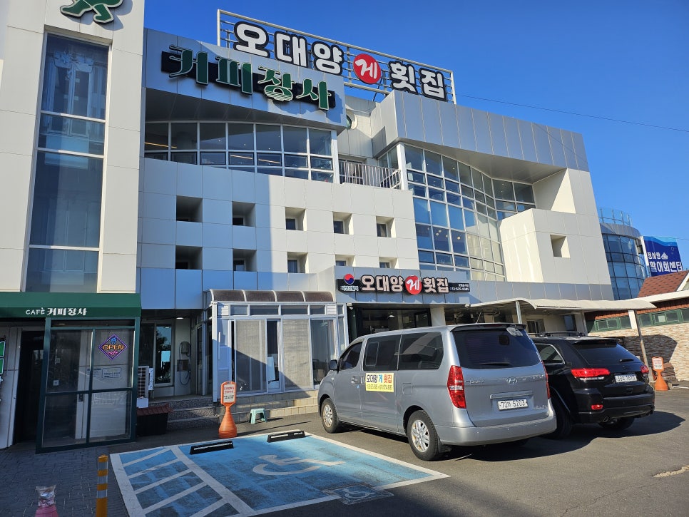 장사항 해안길에 자리한 오대양횟집 외관. 독채 건물로, 바로 앞 부두에 어선이 드나드는 항구가 펼쳐집니다.