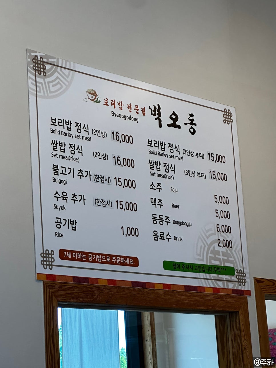 매장에 걸린 실제 메뉴판. 보리밥 정식·쌀밥 정식 모두 2인상 16,000원, 3인상부터는 15,000원이라 적혀 있고, 불고기·수육 추가는 한 접시 15,000원, 공기밥은 1,000원입니다.