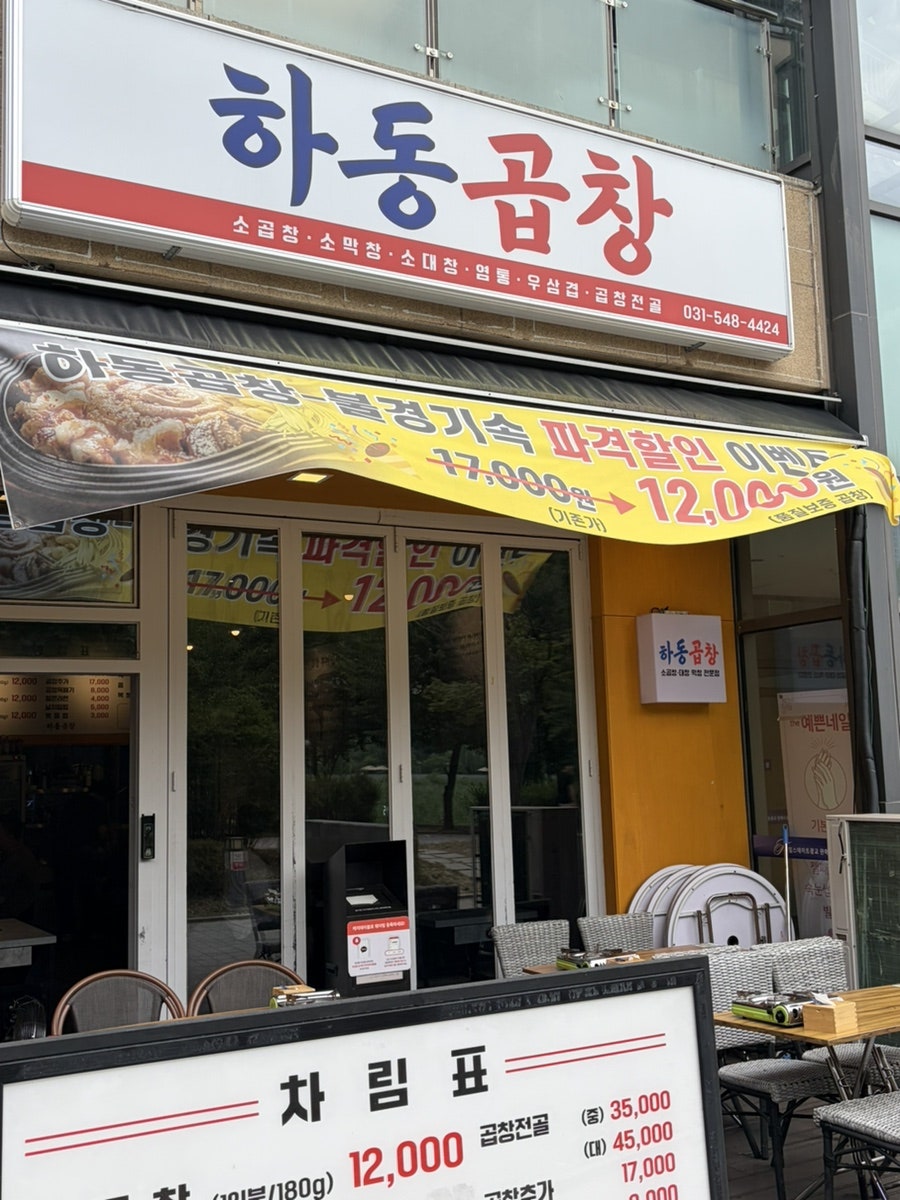 하동곱창 입구 전경. 노란 외벽과 간판, 야외 테이블이 함께 보입니다.