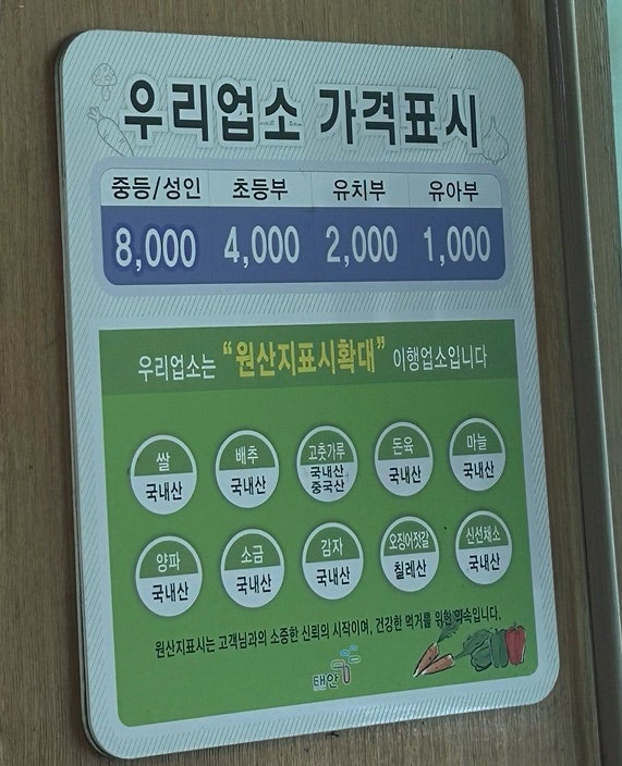 연령별 가격을 명확히 표시한 안내판과 반찬 항목들