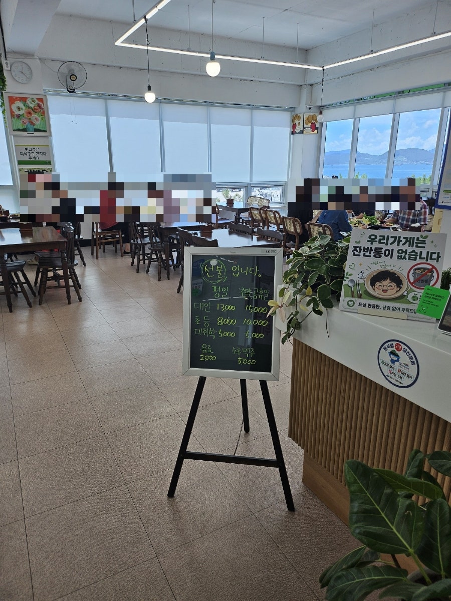 식당 내부 — 창가 자리에서 바라본 바다와 가격 안내판